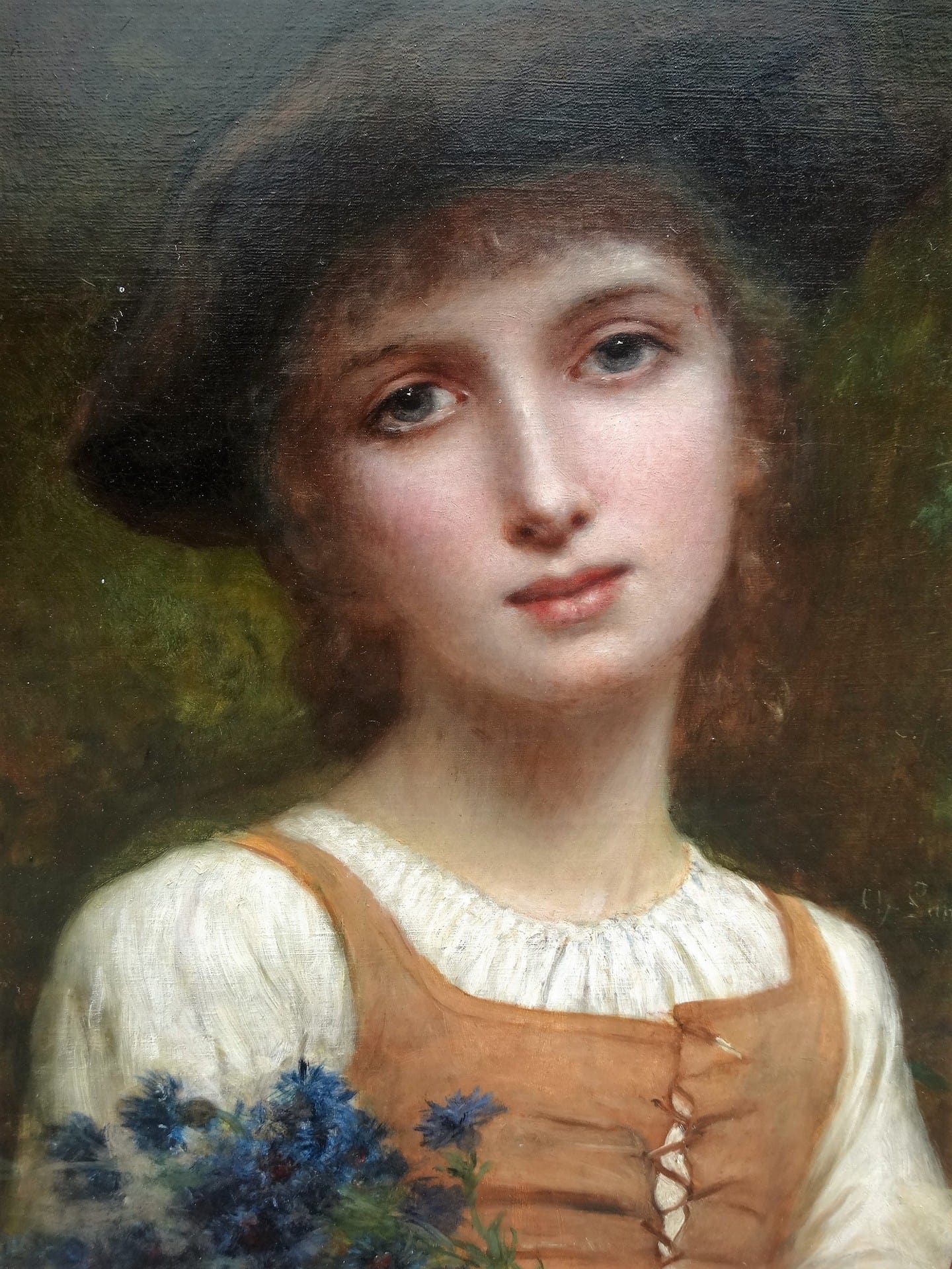 Charles Landelle's "Portrait of a Young Girl". A portrait of a young girl with luminous blue eyes, short light hair, and a European peasant's dress. She holds deep blue flowers