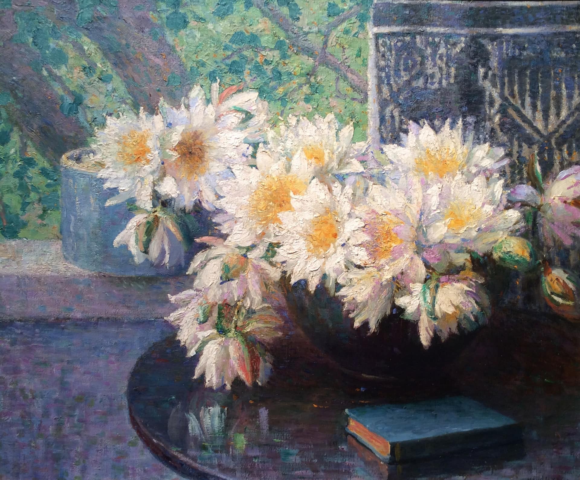 Mason's Still life with Daisies. A vase containing daisies on a table beside a blue book. An open window sits behind.